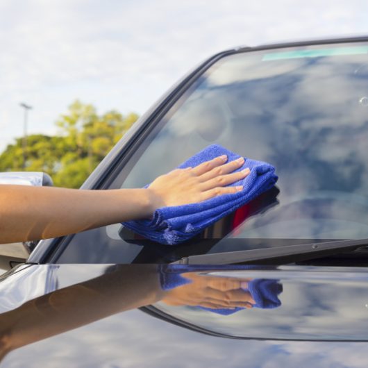 Women's hand wiping on car. Women's hand wiping on car.